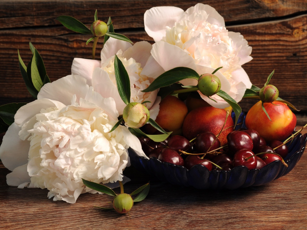 Букет белых пионов на столе с нектарином и черешней