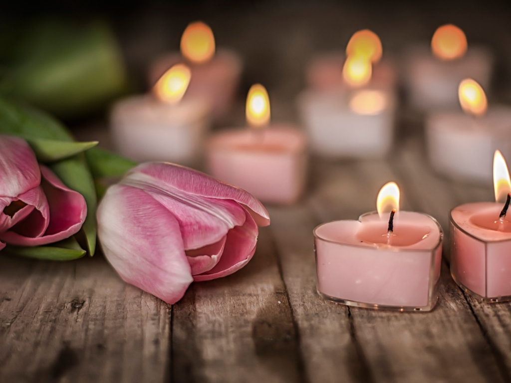 Зажженные стены на столе с розовыми тюльпанами 