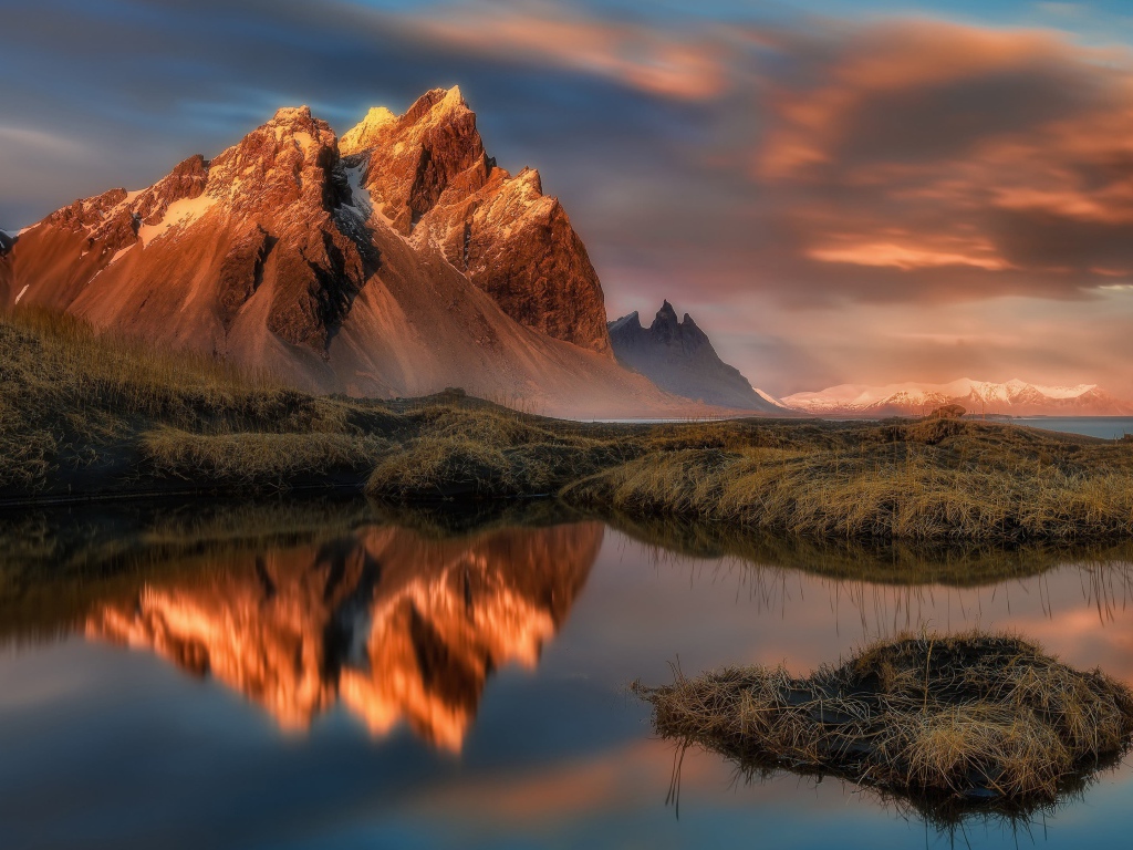 Красивое розовое небо над заснеженными горами у залива 