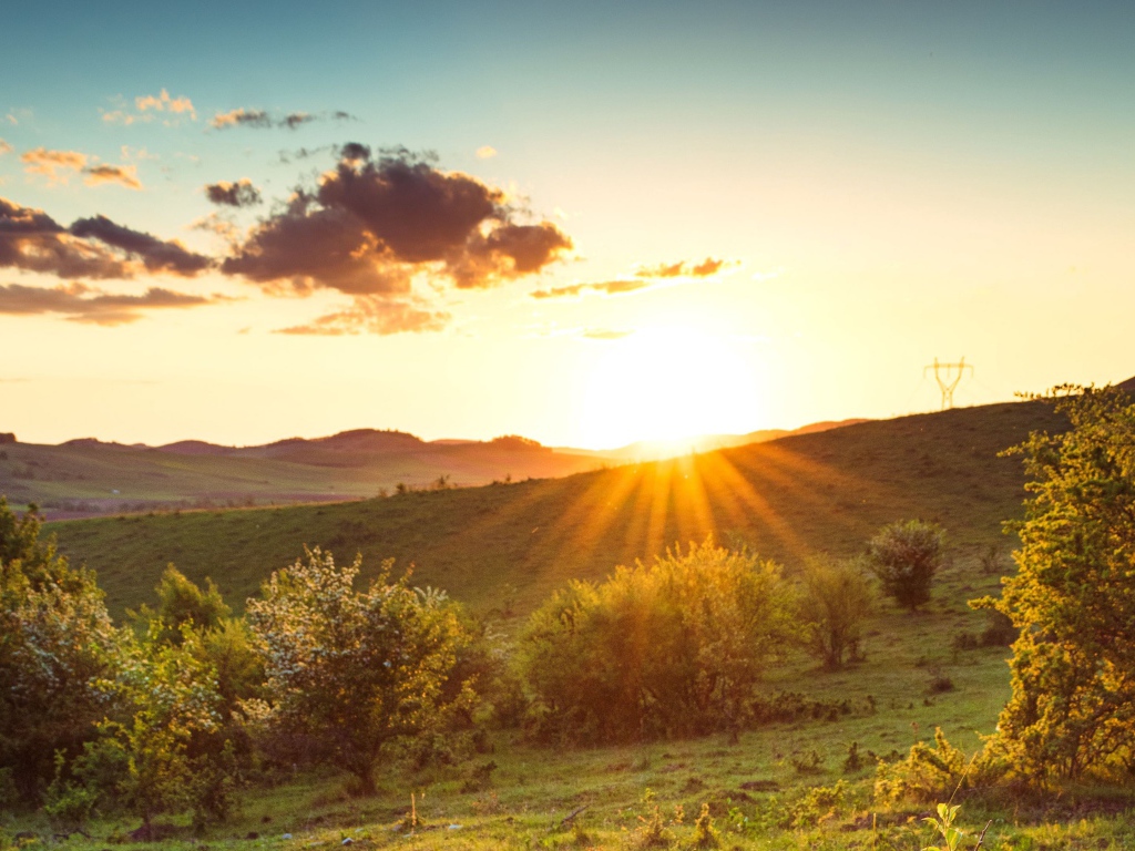 Яркое летнее солнце встает из-за гор 