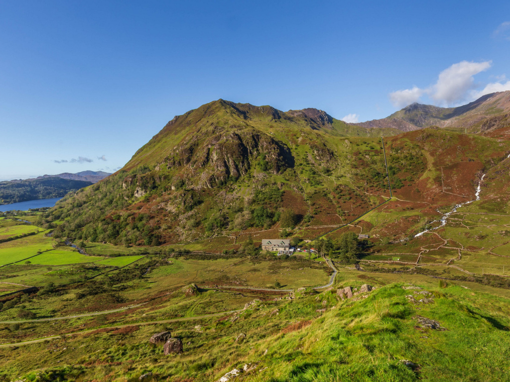 Вид на покрытую зеленью гору под голубым небом