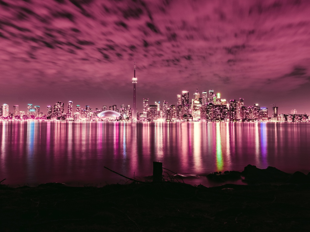 Ночной город под голубым небом отражается в воде 