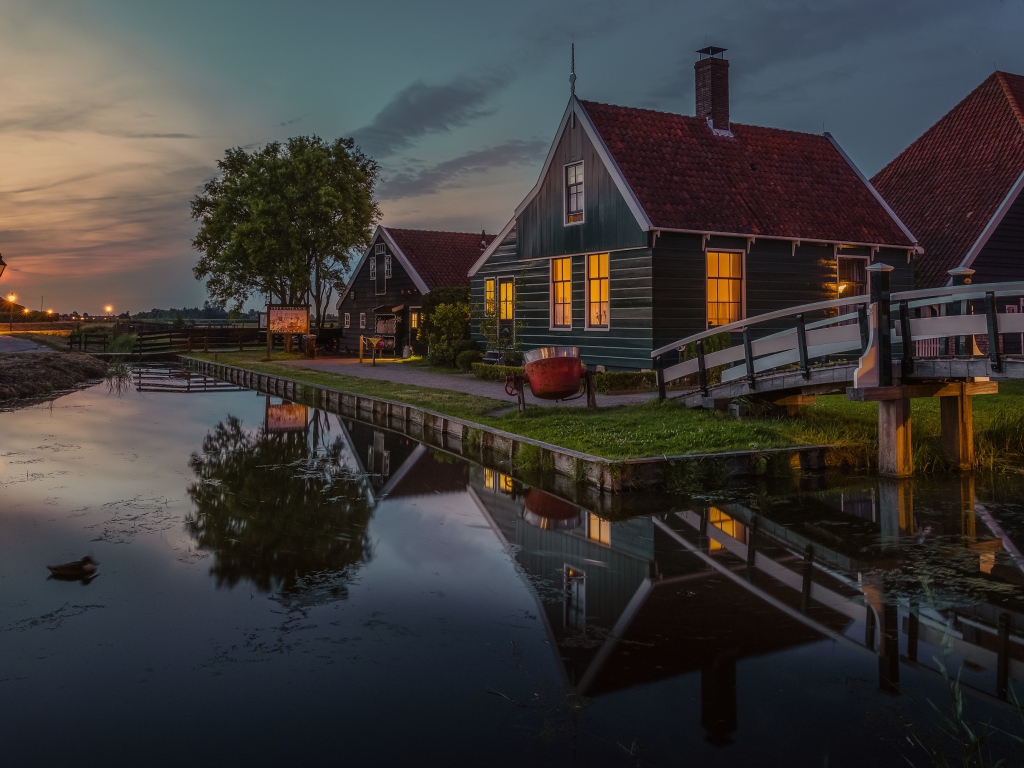 Маленькие дома у пруда вечером 