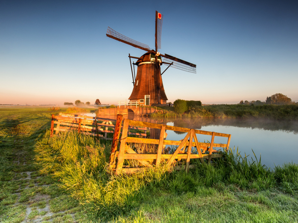 Старая мельница на берегу озера на ферме 