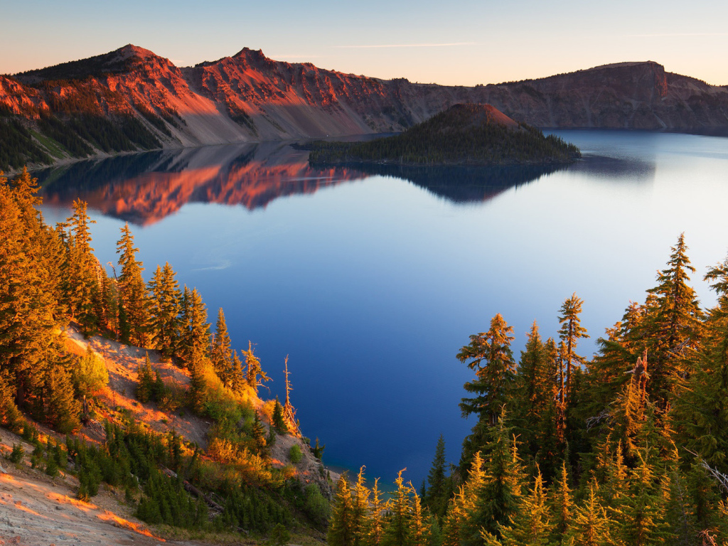 Небо отражается в горном озере в лучах солнца