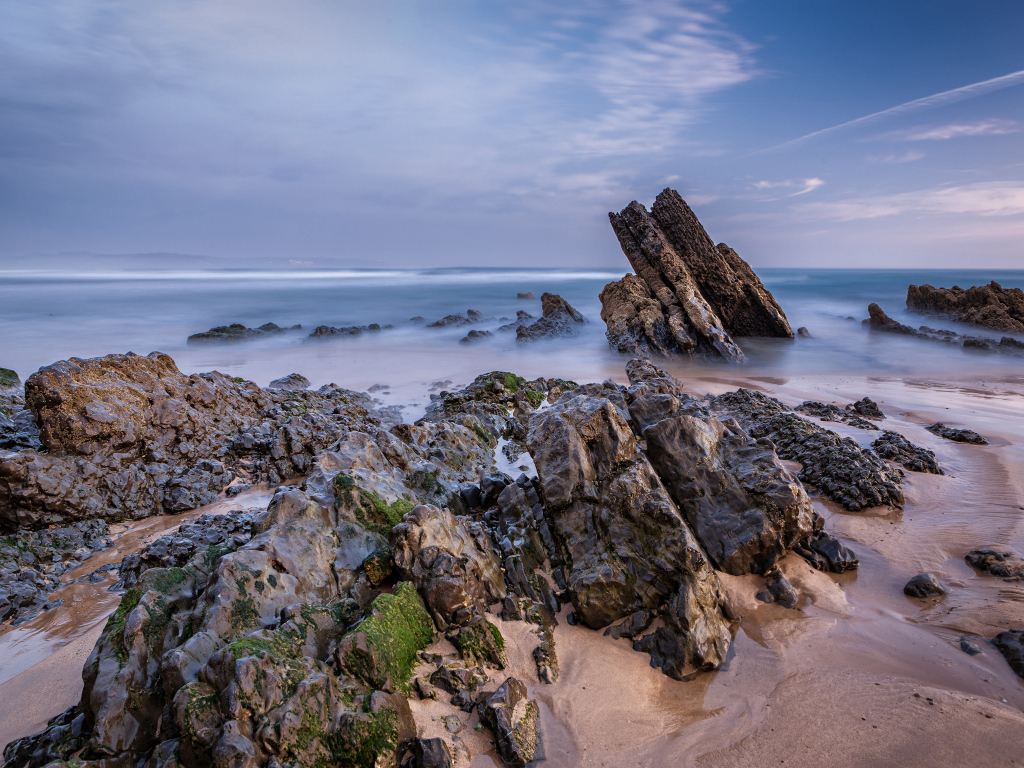 Туман над холодным утренним морем с камнями на берегу 