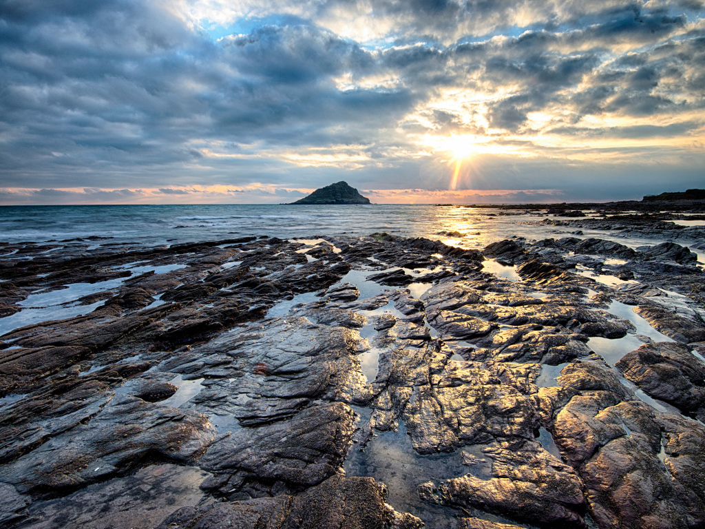 Каменный берег океана в лучах солнца