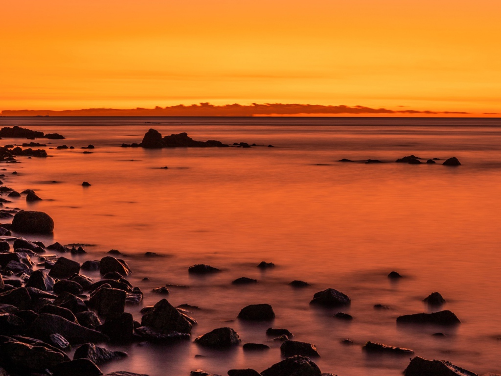 Камни на берегу моря на закате в сумерках 