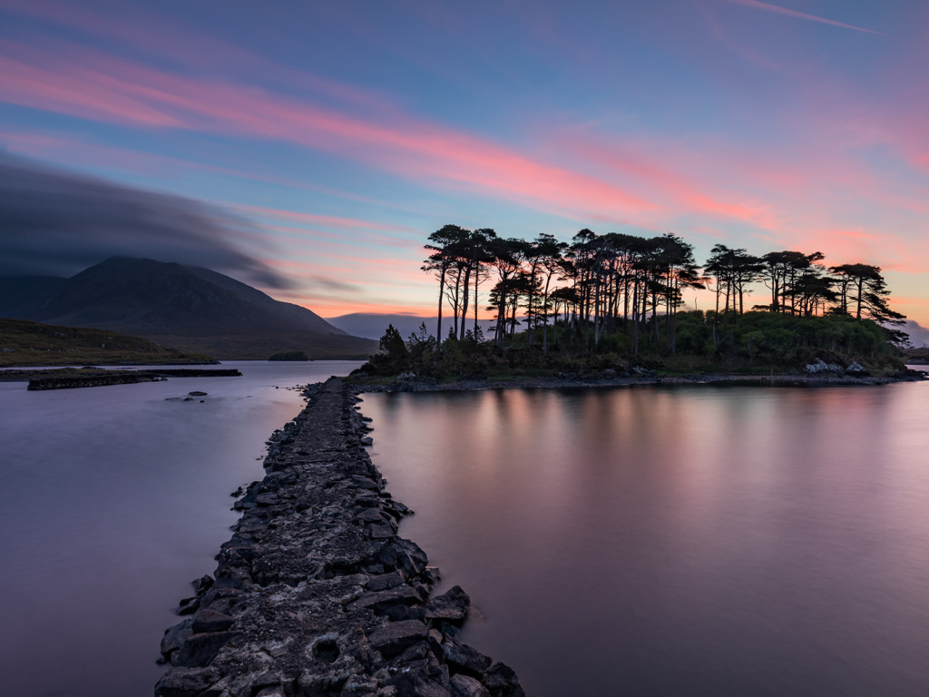Дорога ведет к острову на фоне голубого заката
