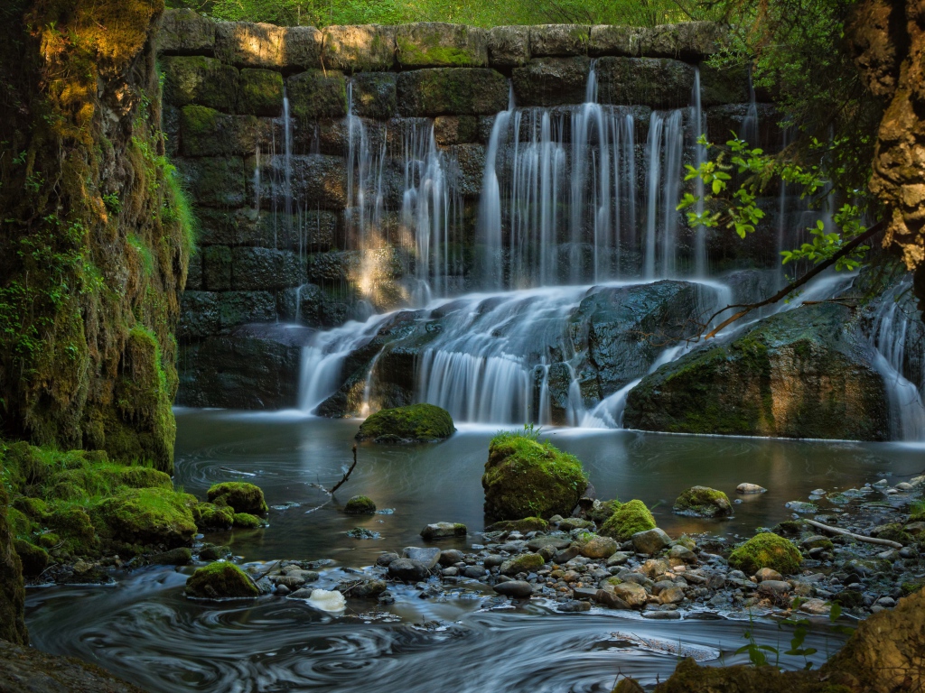 Водопад пробивается сквозь покрытые мхом камни 