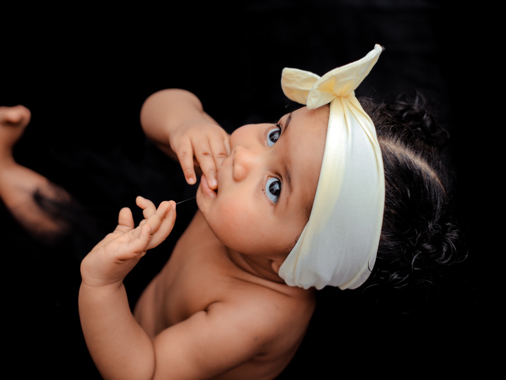 Маленькая темноволосая девочка с бантом на голове 