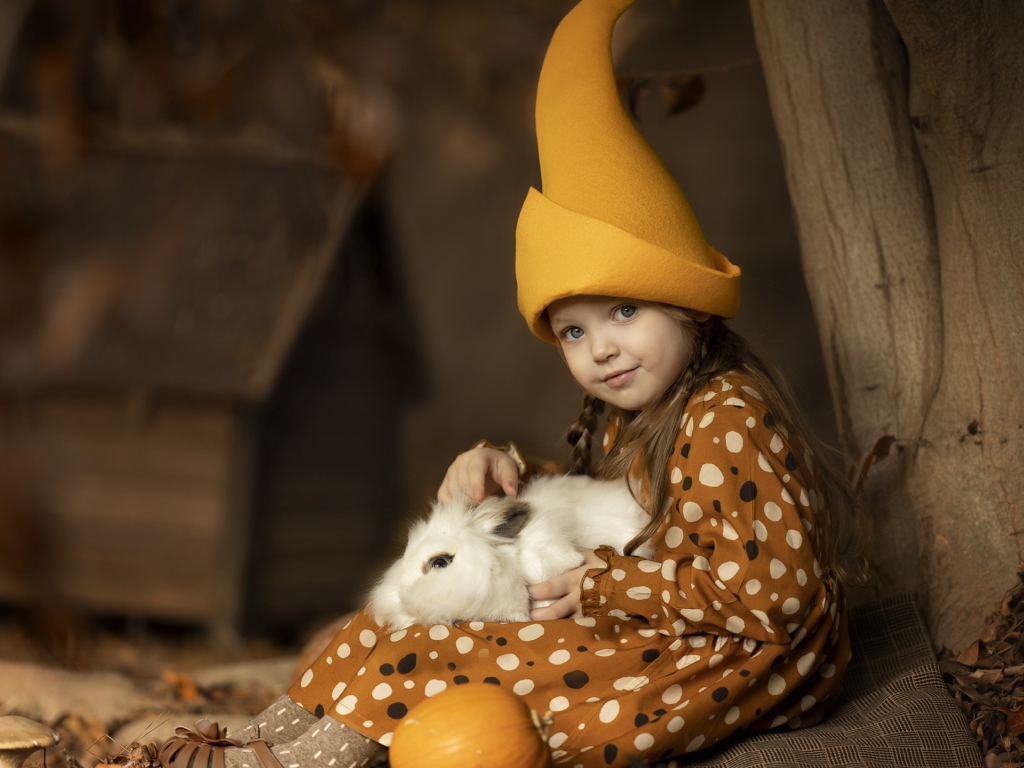 Маленькая смешная девочка в колпаке с кроликом