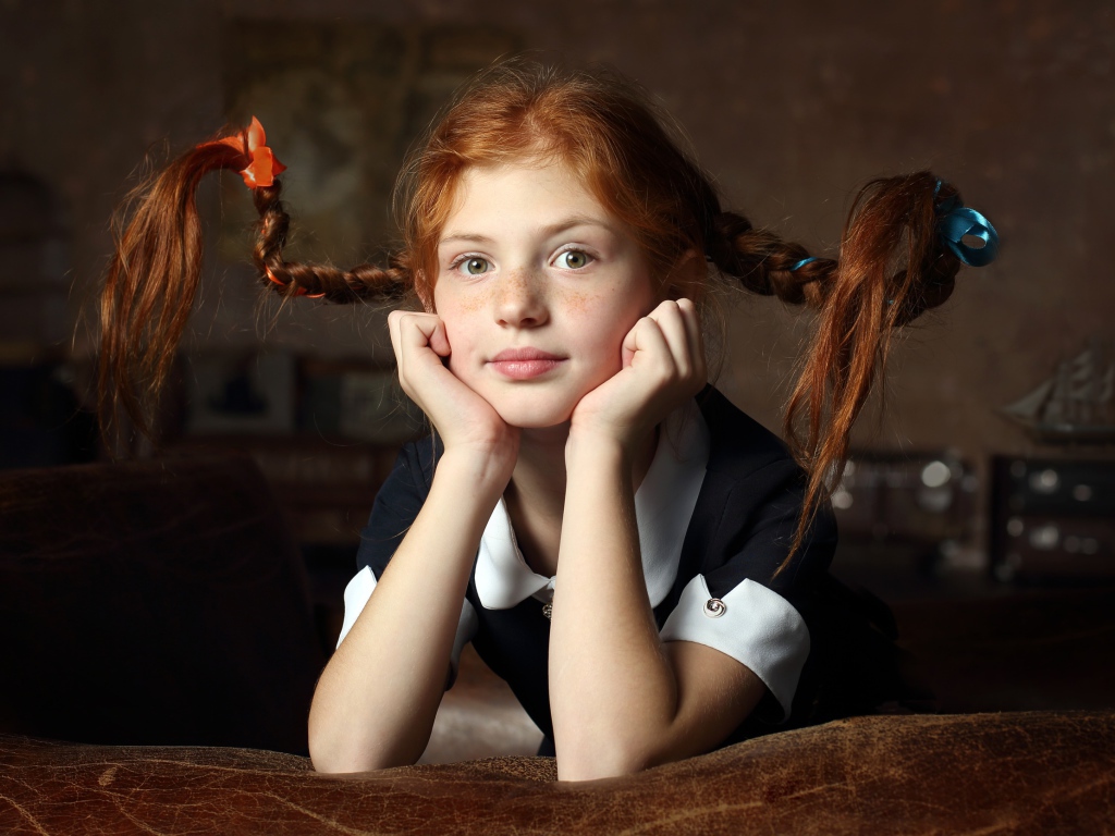 Маленькая смешная девочка с косами в школьной форме 