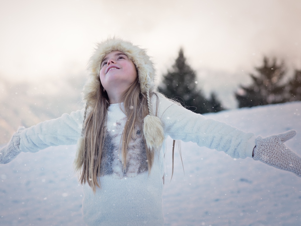 Маленькая девочка в теплой шапке на улице зимой