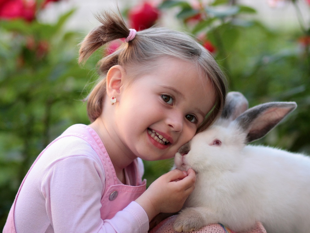 Little smiling girl with a white rabbit