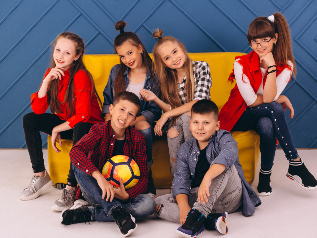 Много модных школьников сидят на диване