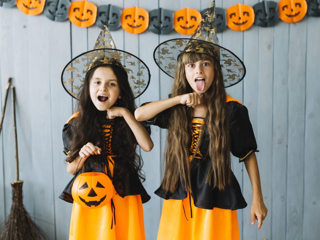 Две маленькие девочки в костюмах ведьмы на Хэллоуин