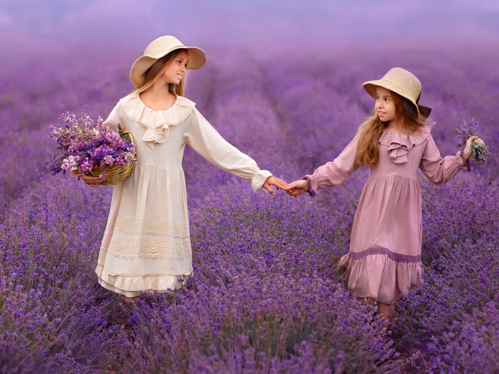 Две маленькие девочки идут по лавандовому полю 