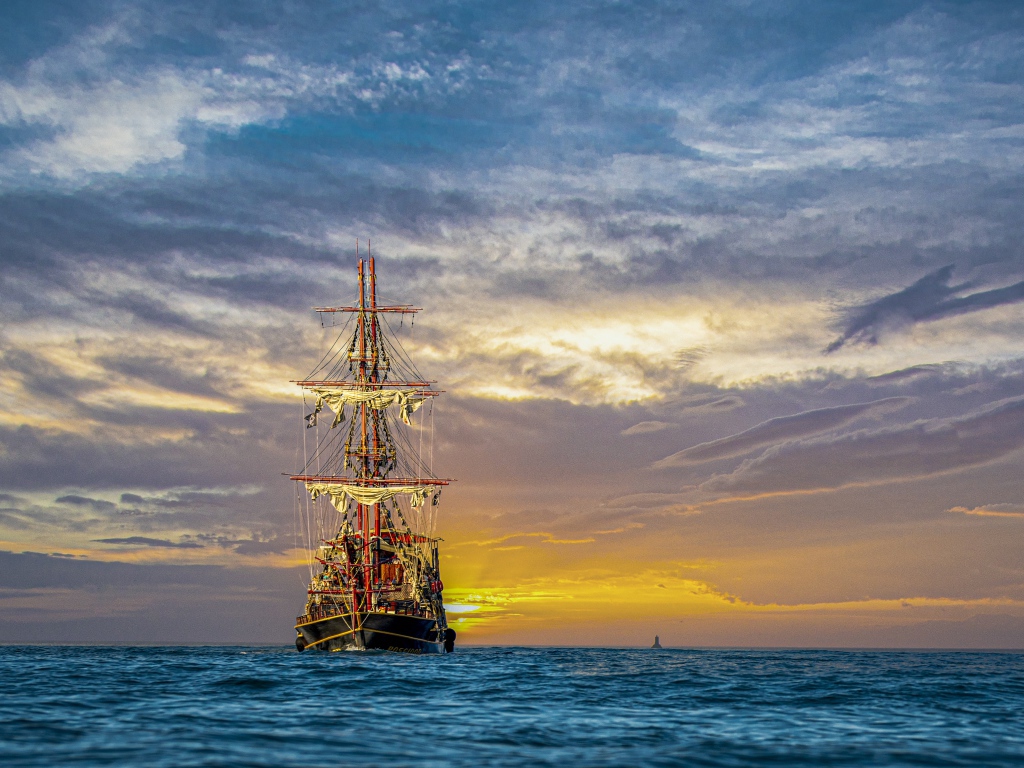 Большой пиратский корабль в море на закате 