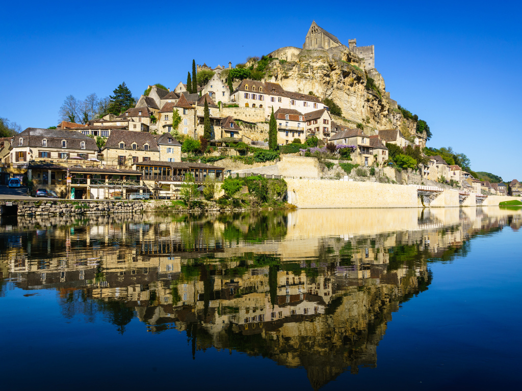 Дома на скале у воды под голубым небом, Франция 