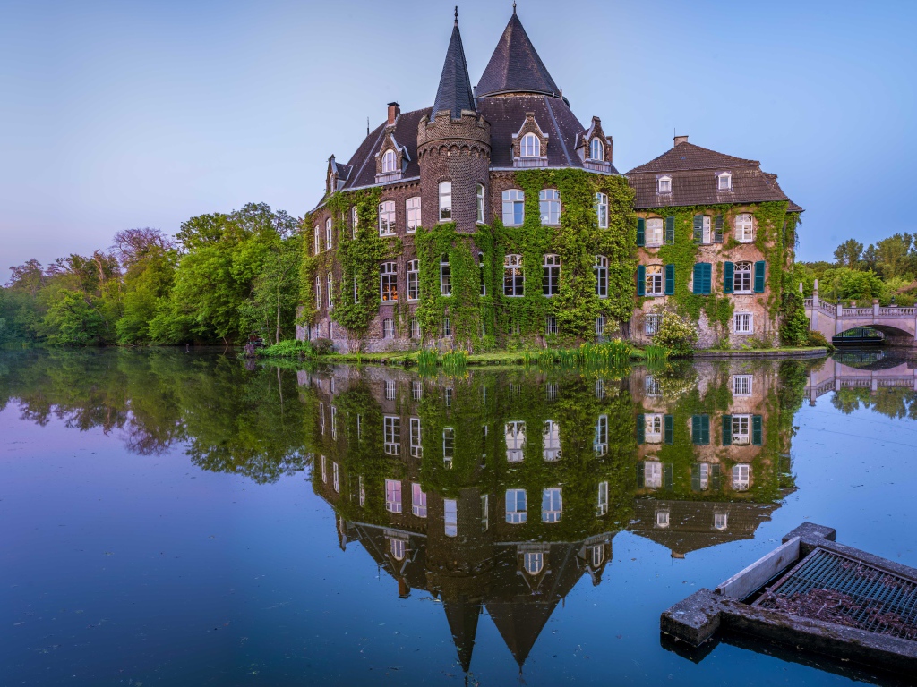 Старинный покрытый зеленью замок Линнеп отражается в воде