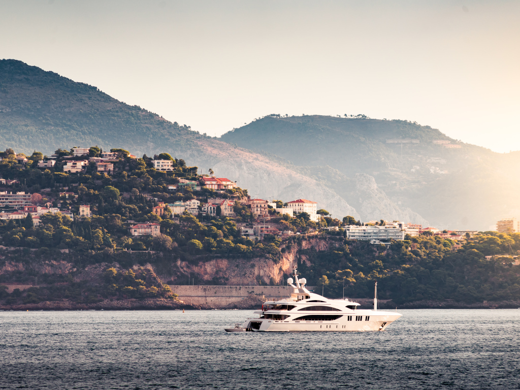 Белая яхта в море на фоне города Монте Карло, Монако