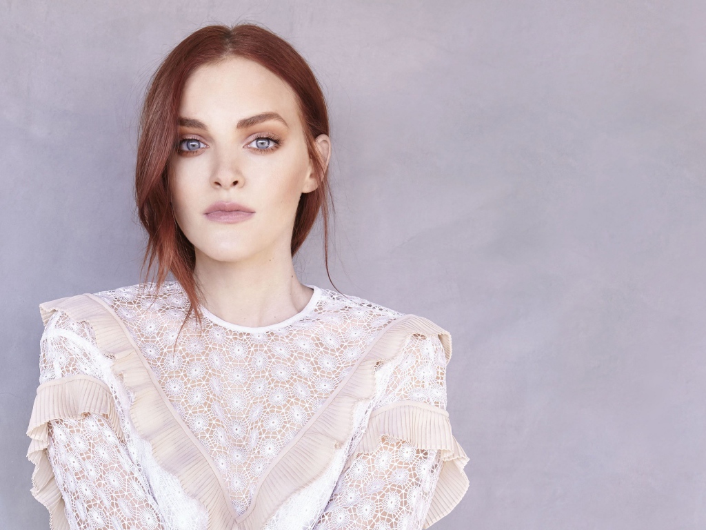 Актриса Мадлен Брюэр в белом платье на фоне стены