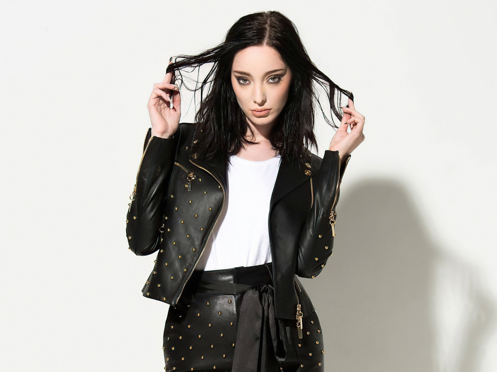 Американская актриса Эмма Дюмон в черном кожаном костюме на белом фоне