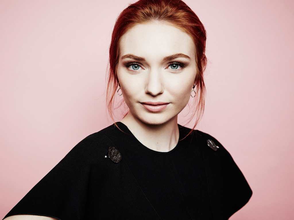Beautiful red-haired actress Eleanor Tomlinson on a pink background