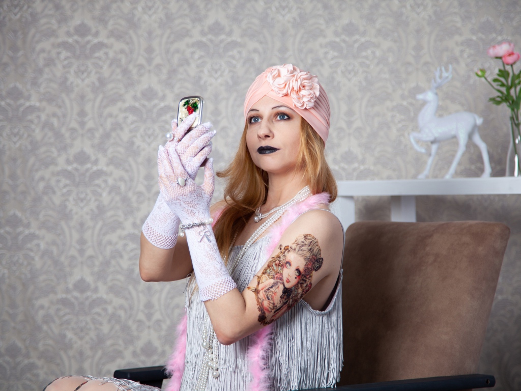 Красивая ретро девушка с татуировкой на руке