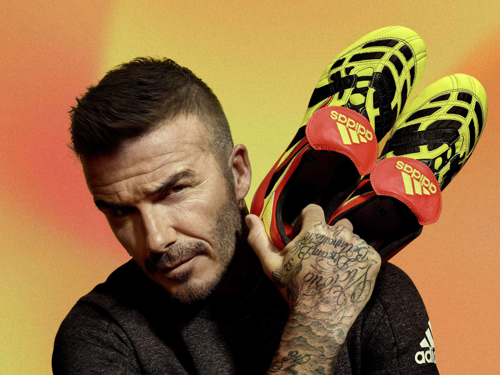 Футболист Дэвид Бекхэм с кедами Адидас в руке