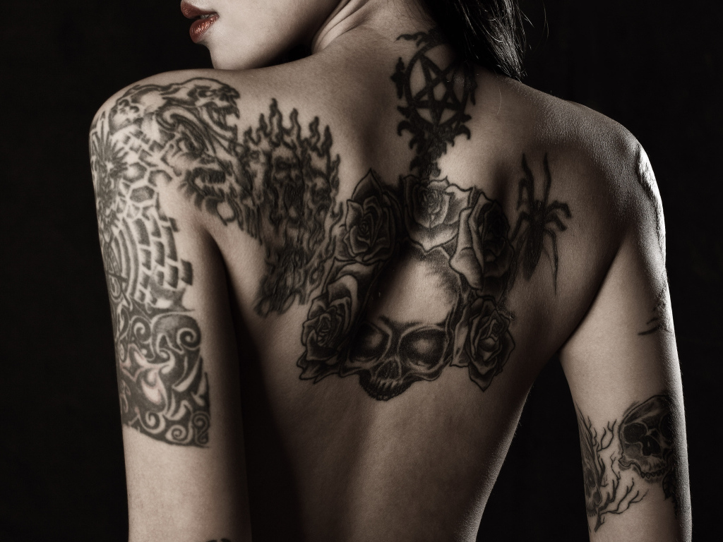 Girl with tattoos on her arms and back