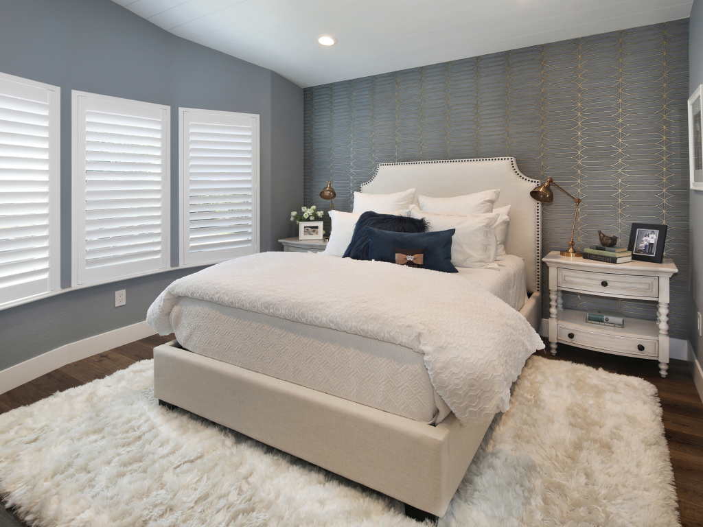 Высокая кровать в спальной комнате в серых тонах