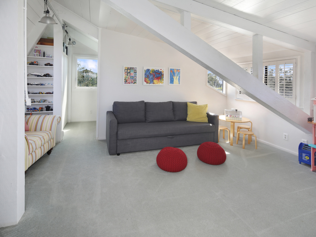 Большой серый диван в белой гостиной комнате