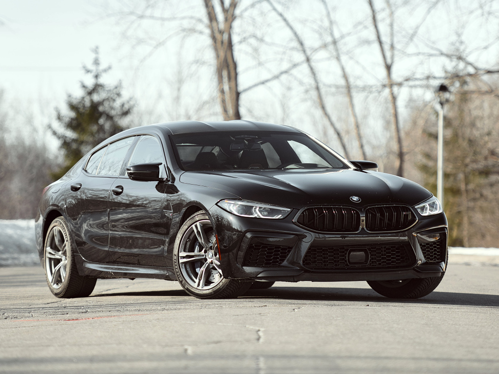 Черный автомобиль BMW M8 в лучах солнца