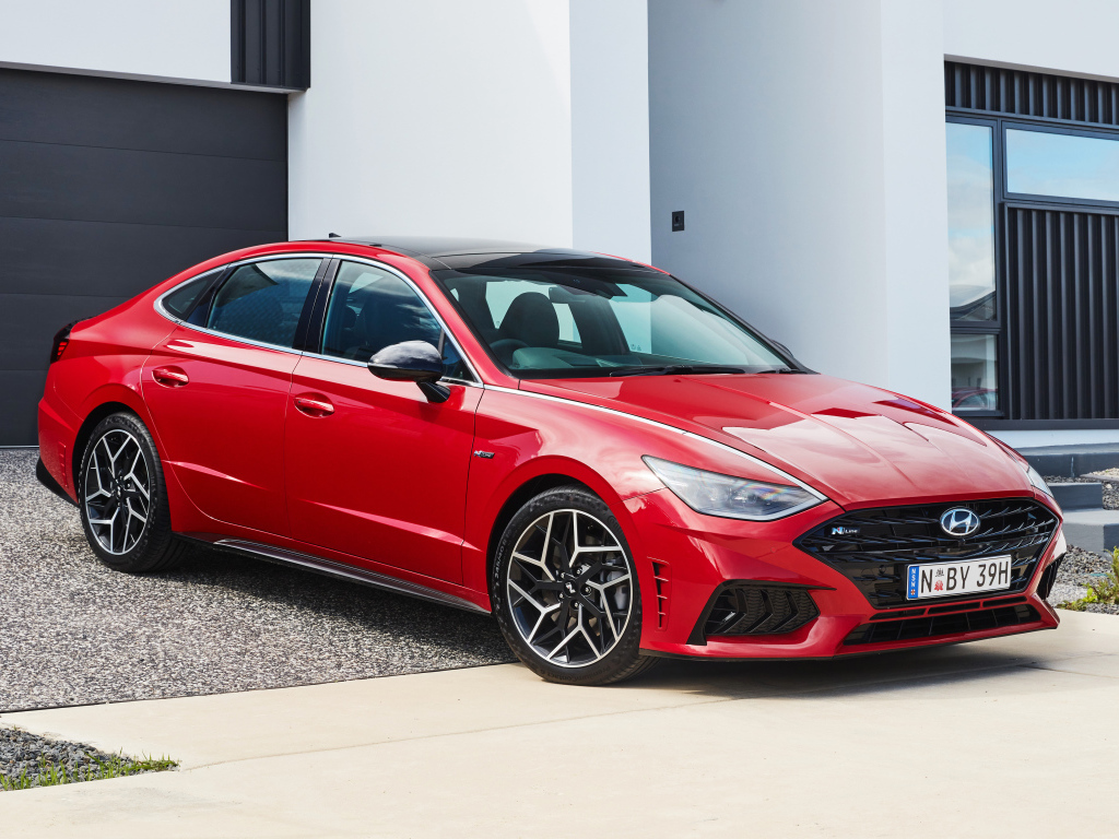 Красный автомобиль Hyundai Sonata N Line 2021 года у гаража