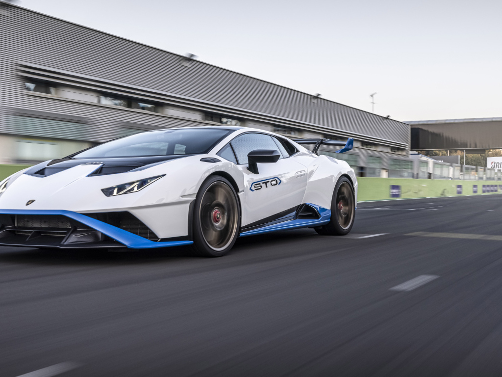 Белый автомобиль Lamborghini Huracán STO 2021 года на стадионе 