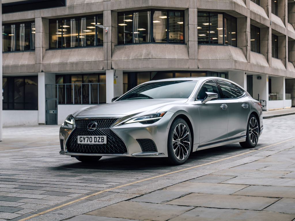 Серебристый автомобиль Lexus LS 500h 2021 года в городе у дома