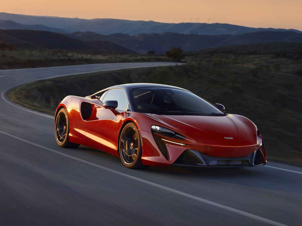 Красный автомобиль McLaren Artura, 2022 года на трассе