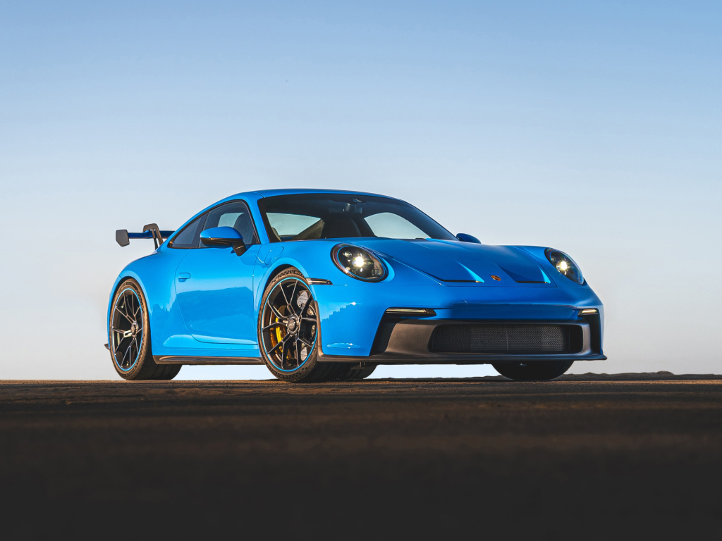 Синий автомобиль Porsche 911 GT3 2021 года на фоне неба