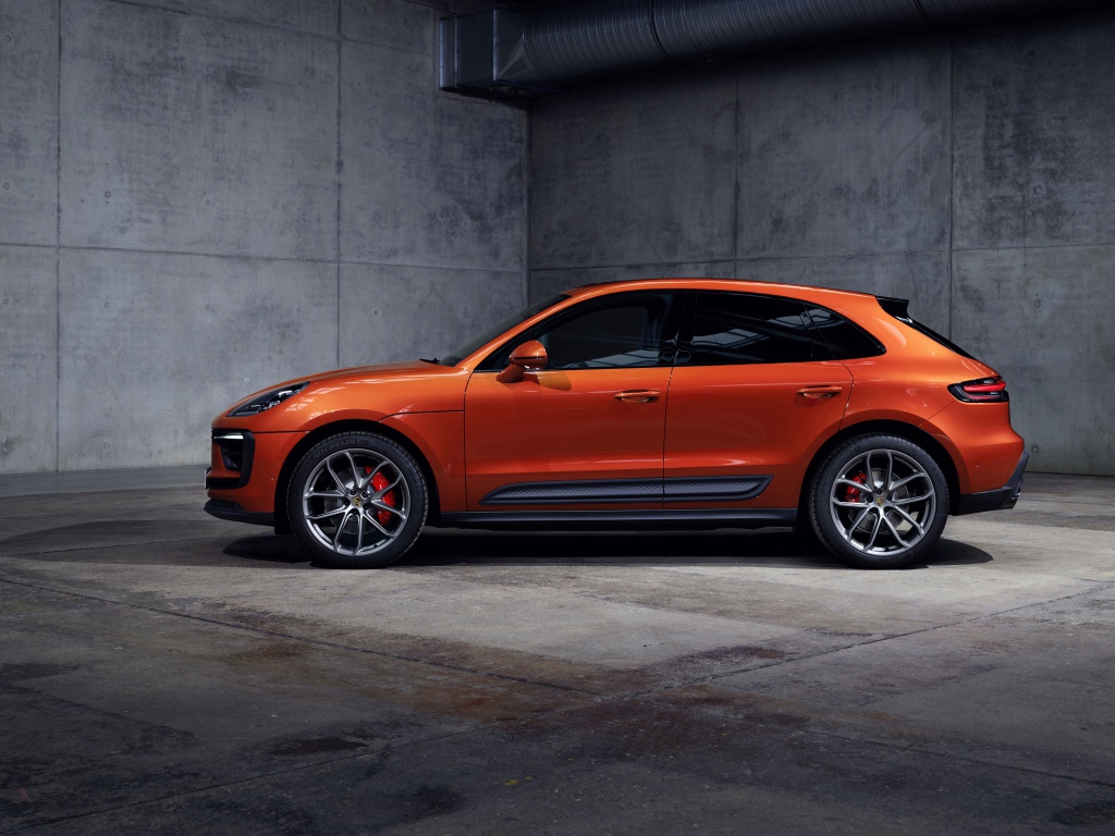 Оранжевый Porsche Macan S 2021  года на сером фоне