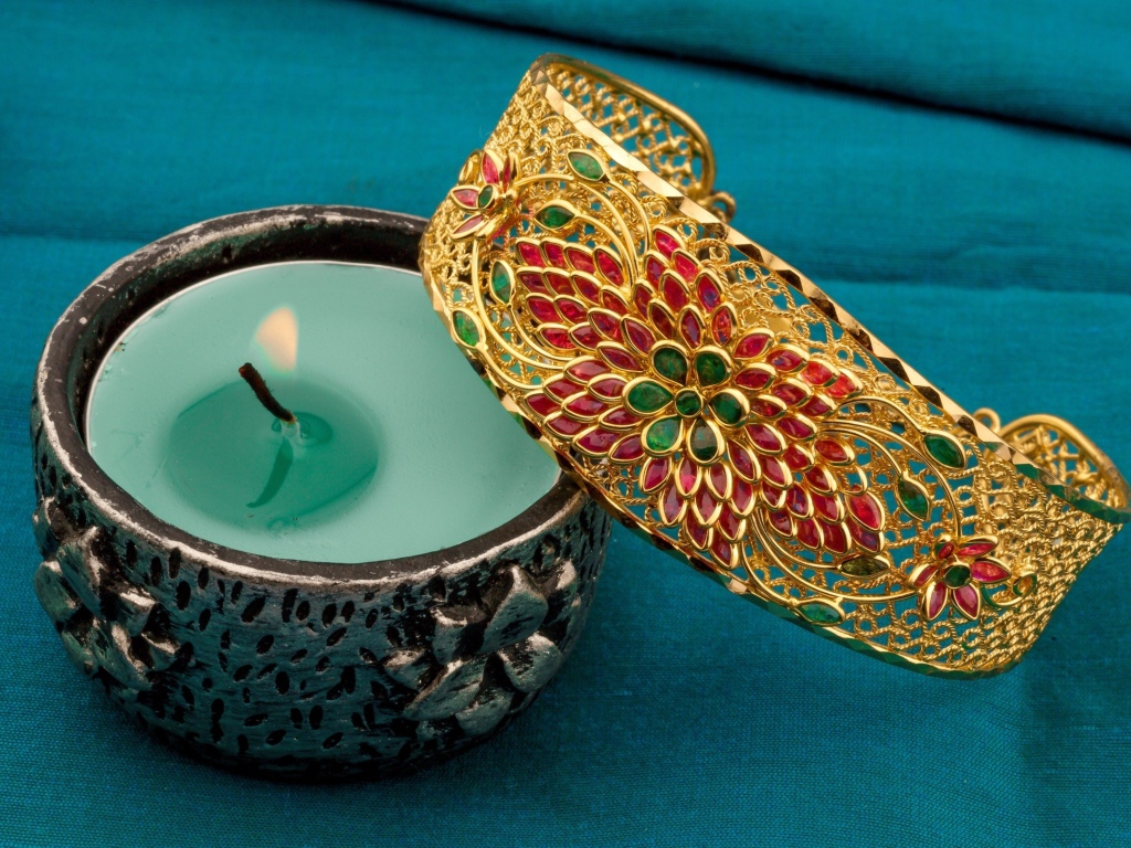 Красивый браслет со свечой на синем покрывале 