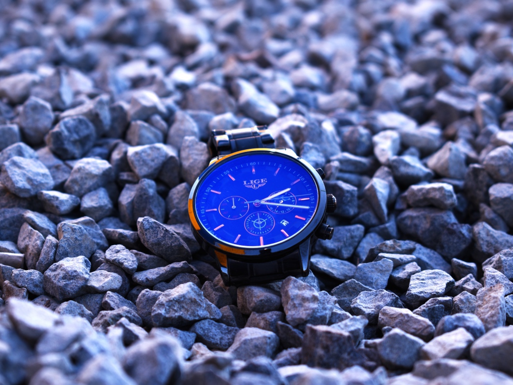 Голубые наручные часы лежат на камнях