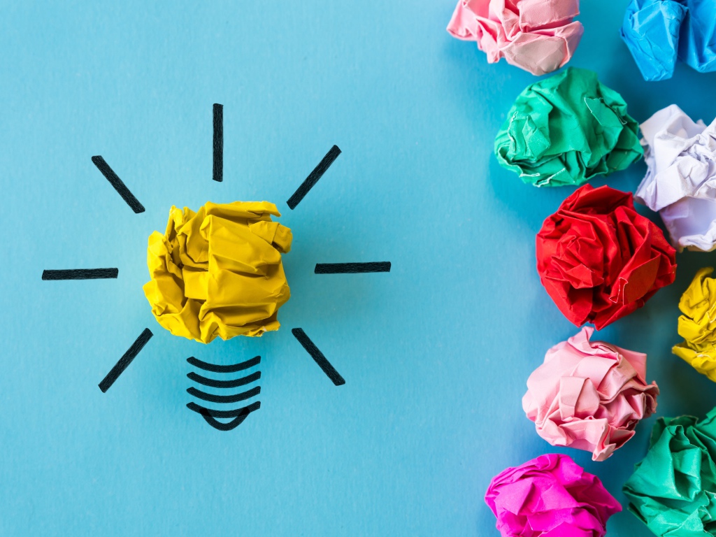 Комки разноцветной бумаги на голубом фоне 