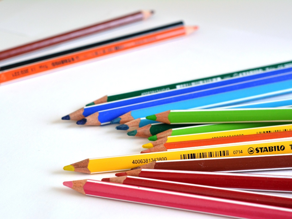 Разноцветные карандаши на белом столе 