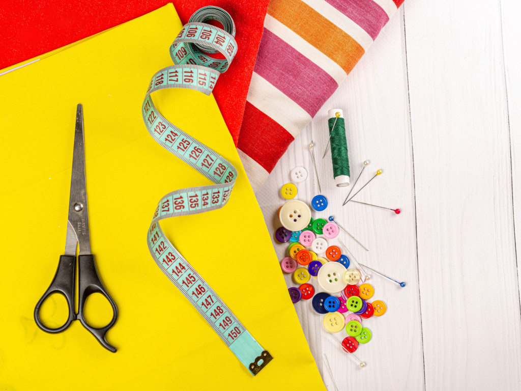 Разноцветная бумага и набор для шитья на столе 