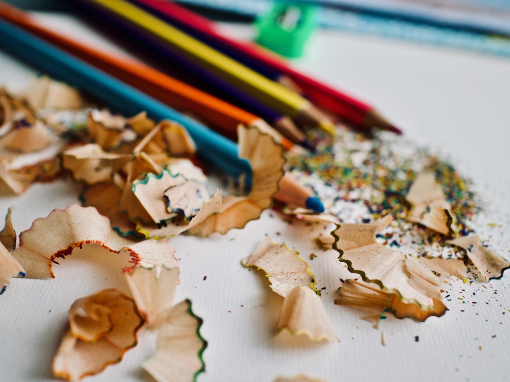 Карандаши со стружкой на сером столе 