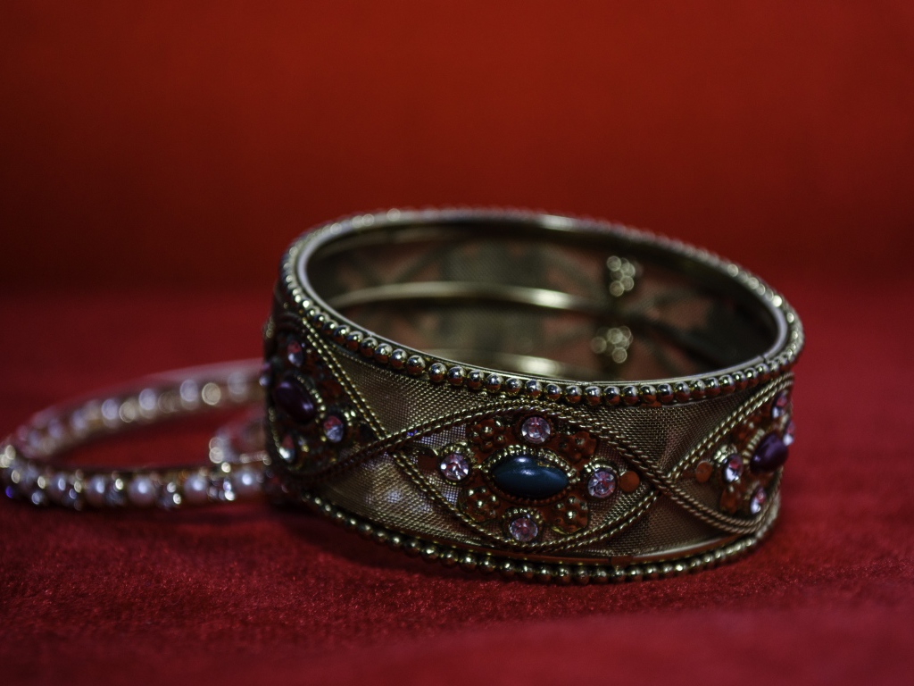 Красивый браслет с драгоценными камнями на красном фоне 