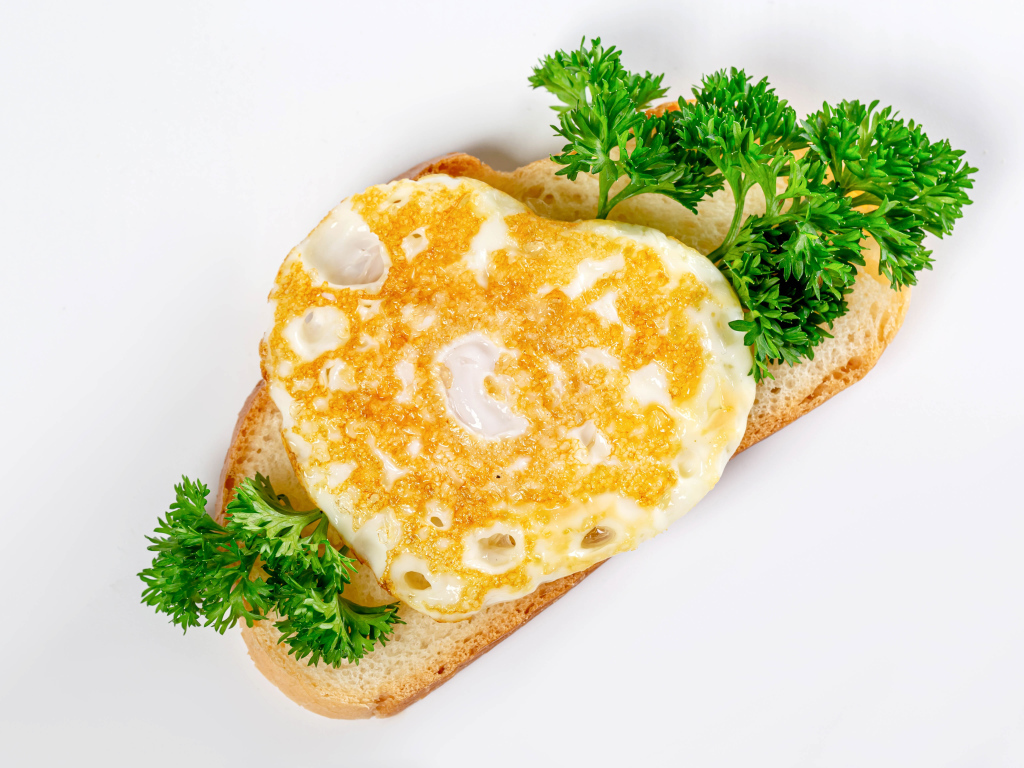 Кусок хлеба с яичницей и петрушкой