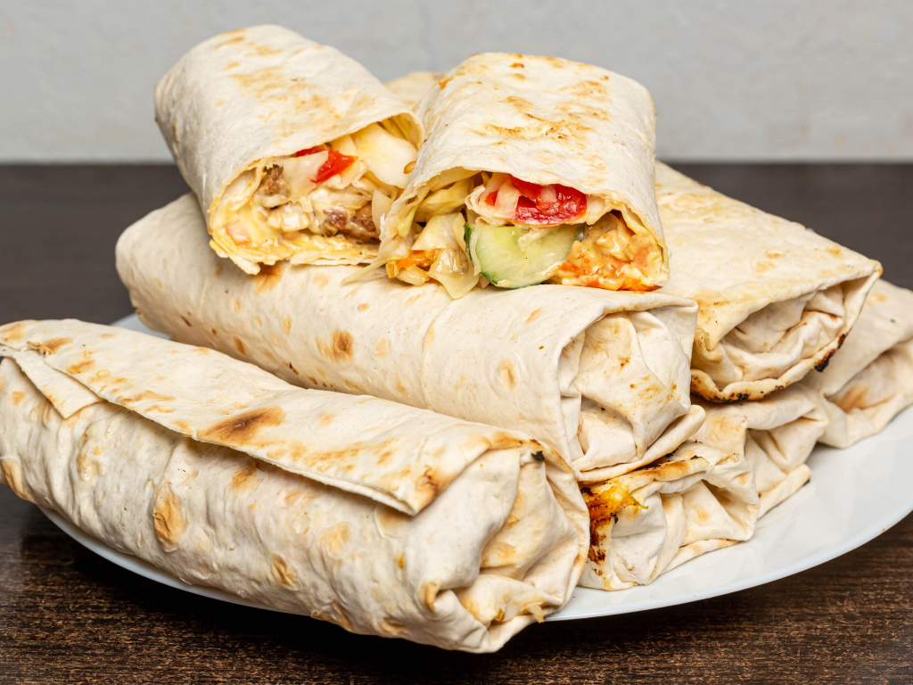 Аппетитная шаурма в лаваше на столе 